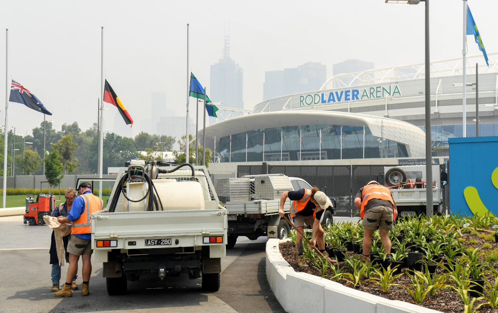 Gardeners work as smoke haze from unprecendented bushfires hover over the Rod Laver Arena ahead of the Australian Open in Melbourne January 14, 2020. u00e2u20acu201d AFP pic