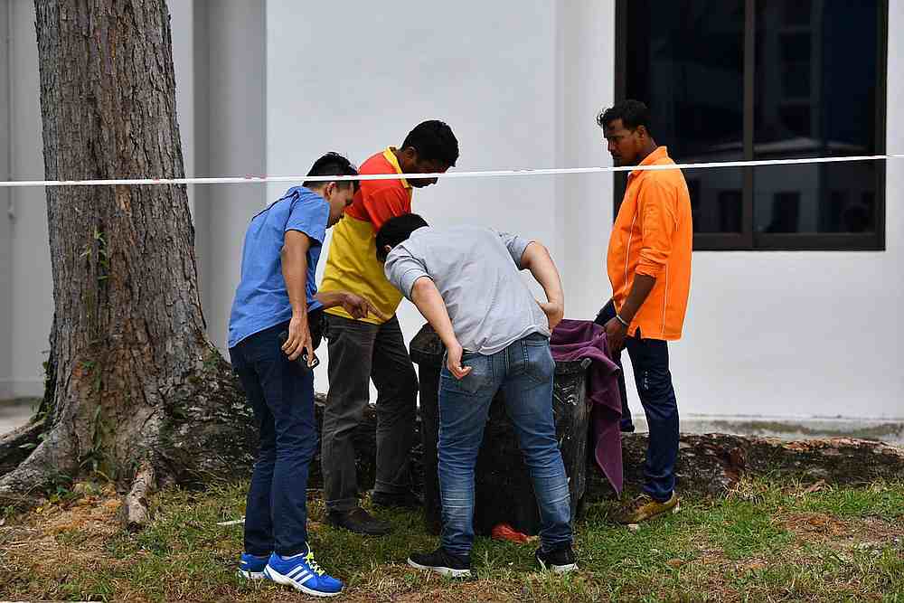 Police officers and cleaners inspect the contents of a bin at a rubbish chute, after a baby was found alive among rubbish in a bin at a public housing estate in Singapore January 7, 2020. u00e2u20acu201d The Straits Times pic via Reuters