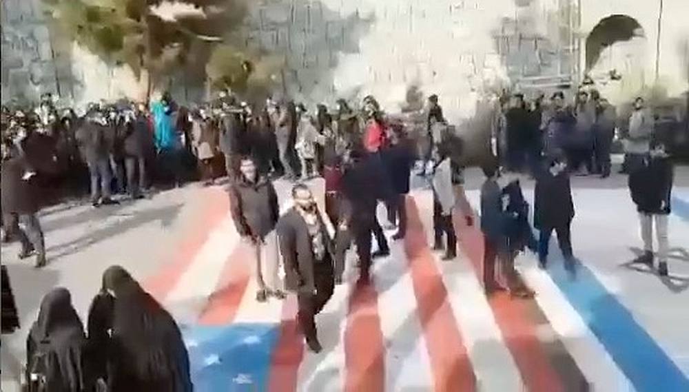 People walk on US and Israeli flags while others avoid stepping on the flags by walking around them, at the Shahid Beheshti University in Tehran, Iran January 12, 2020. u00e2u20acu201d @MAMLEKATE/social media image via Reuters