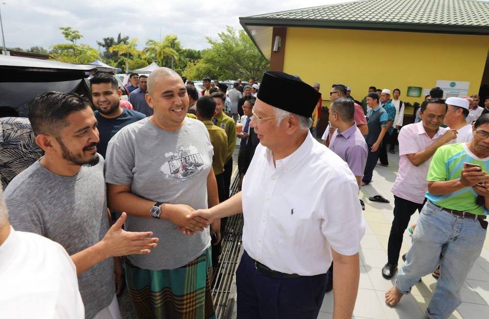 Datuk Seri Najib Razak greets residents of Membakut accompanied by several state Umno leaders. — Picture via Facebook/NajibRazak