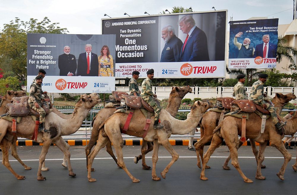 Border Security Force soldiers ride their camels past hoardings with the images of Indiau00e2u20acu2122s Prime Minister Narendra Modi, US President Donald Trump and first lady Melania Trump, as they take part in a rehearsal for a road show ahead of Trumpu00e2u20acu2122s visit, i