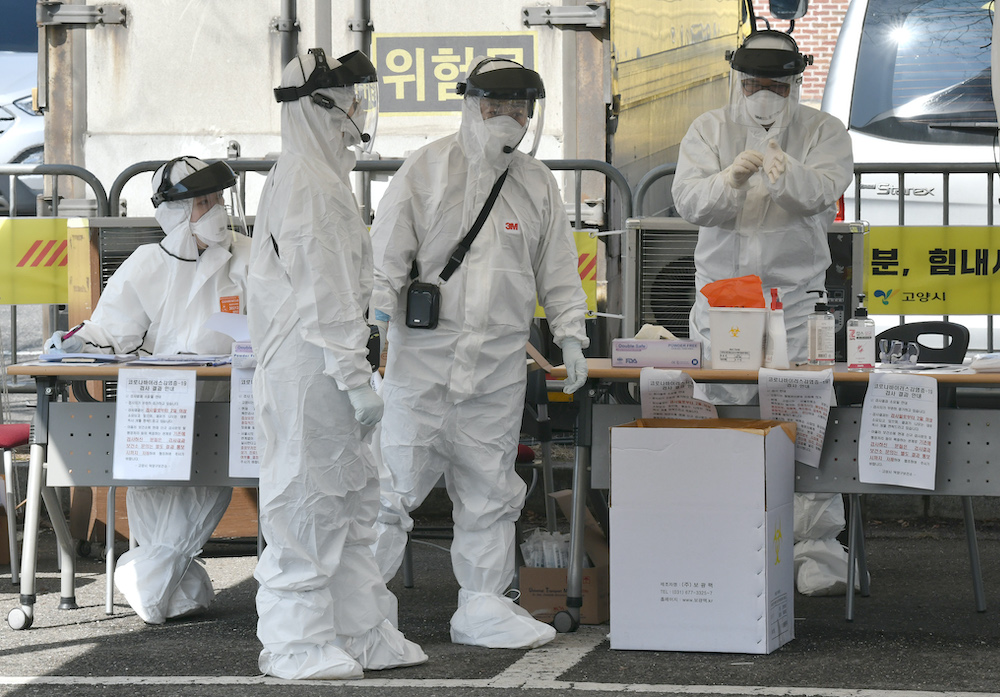Medical members wearing protective gear talk as they check drivers with suspected symptoms of the COVID-19 coronavirus, at a u00e2u20acu02dcdrive-throughu00e2u20acu2122 virus test facility in Goyang, north of Seoul, on February 29, 2020. u00e2u20acu201d AFP pic