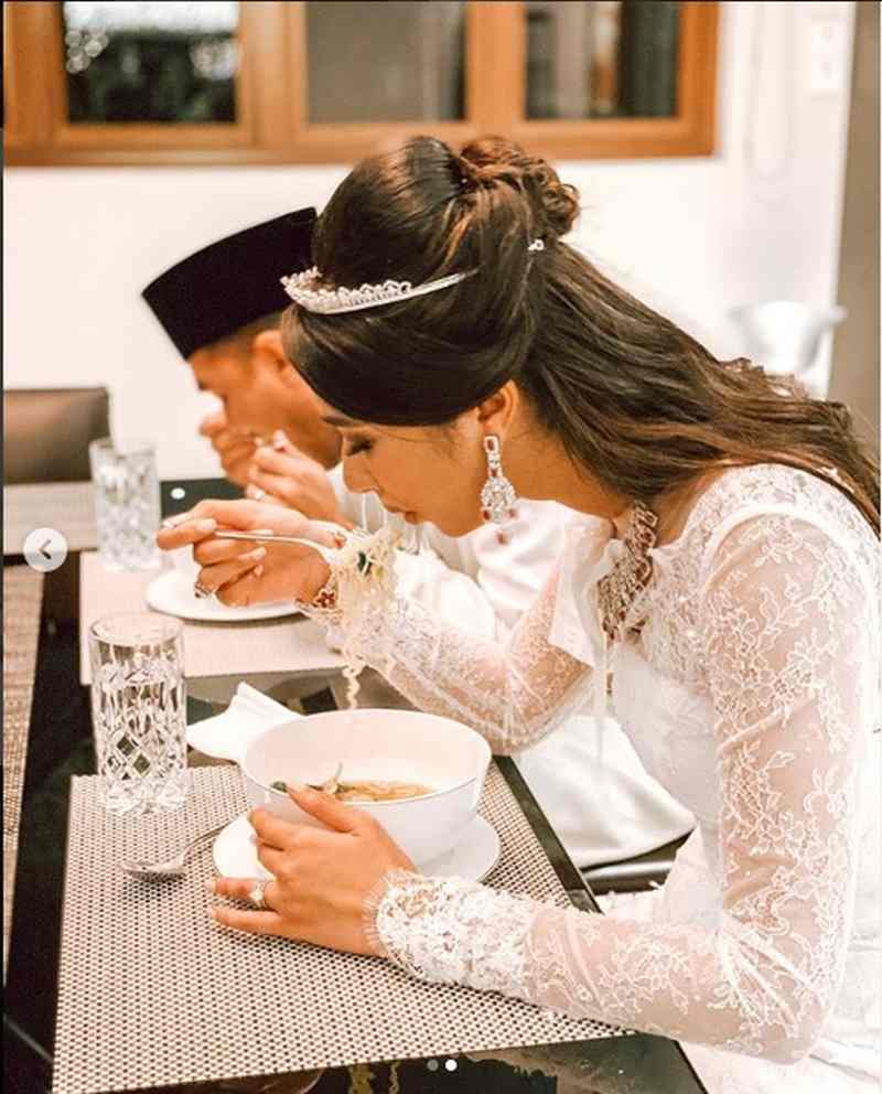 Ally shared a snapshot of the newlyweds slurping on instant noodles while dressed in their wedding outfits. ― Picture via Instagram/Ally Mukhriz