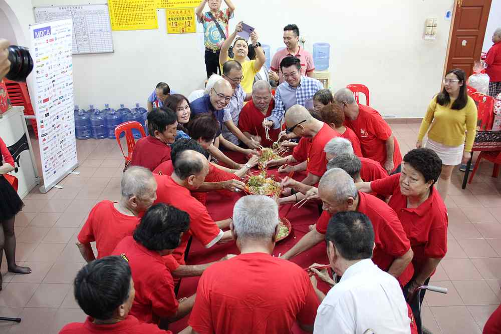 Residents of the Tiam Yam Toh Teng home along with MRCA indulge in tossing the 'yee sang.' — Picture courtesy of MRCA