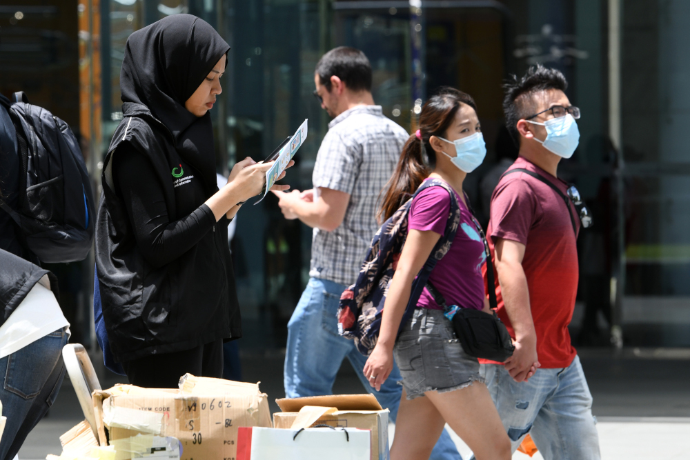 A volunteer from Singapore’s Communication Ministry prepares to collect feedback from the public on the coronavirus outbreak situation at the Raffles Place financial business district in Singapore February 5, 2020. — AFP pic