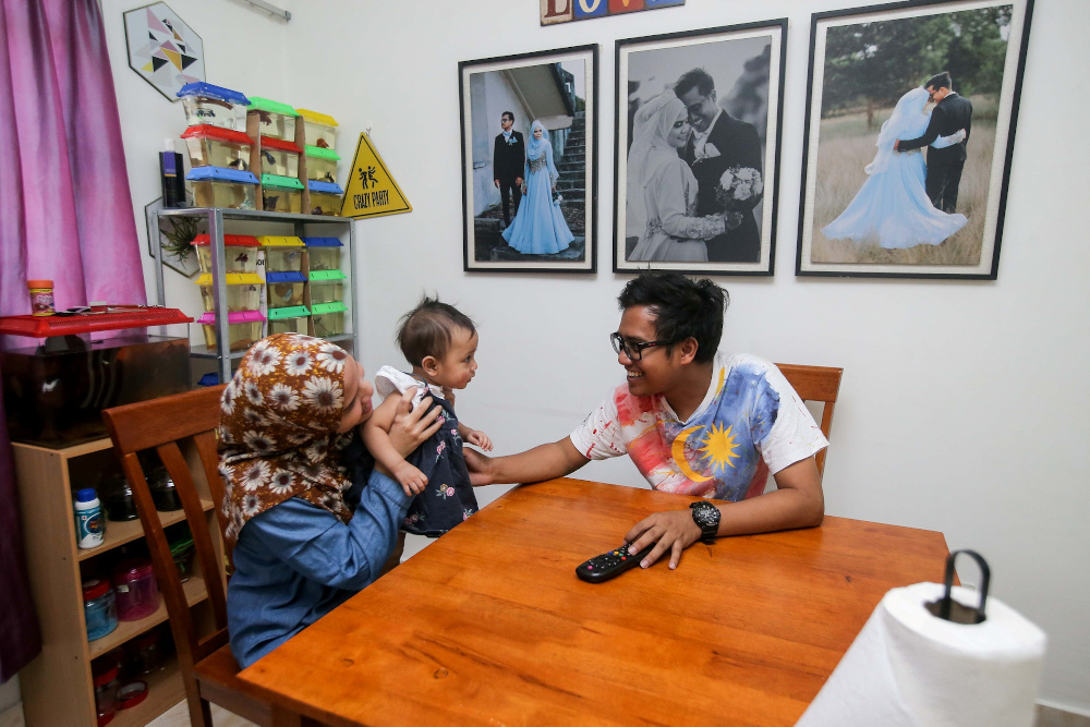 Nor Hanis Ahmad Shamsi, 29, and her husband Mohd Zulfadhli Zulkarnain, 27, together with their child 10-month-old Nur Zara Zalikha, spend their time at home following the movement control order to curb Covid-19 infection. — Picture by Farhan Najib