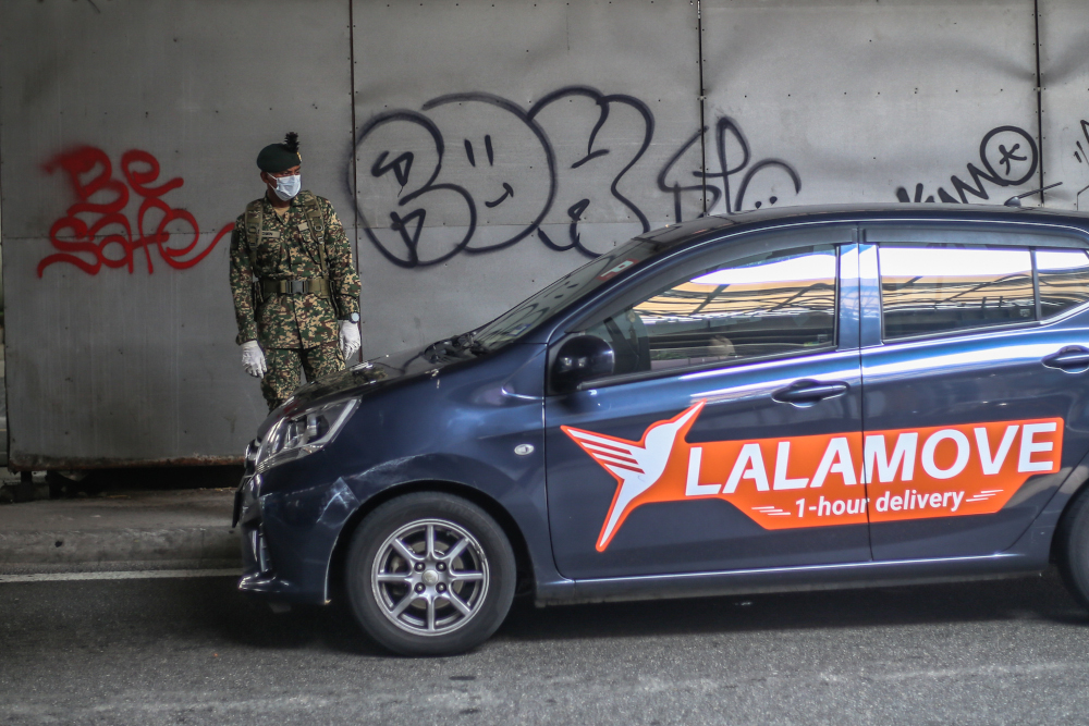 Soldiers and police officers conducting checks at a roadblock on day five of the movement control order (MCO) at Jalan Loke Yew in Kuala Lumpur March 22, 2020. u00e2u20acu201d Picture by Firdaus Latif