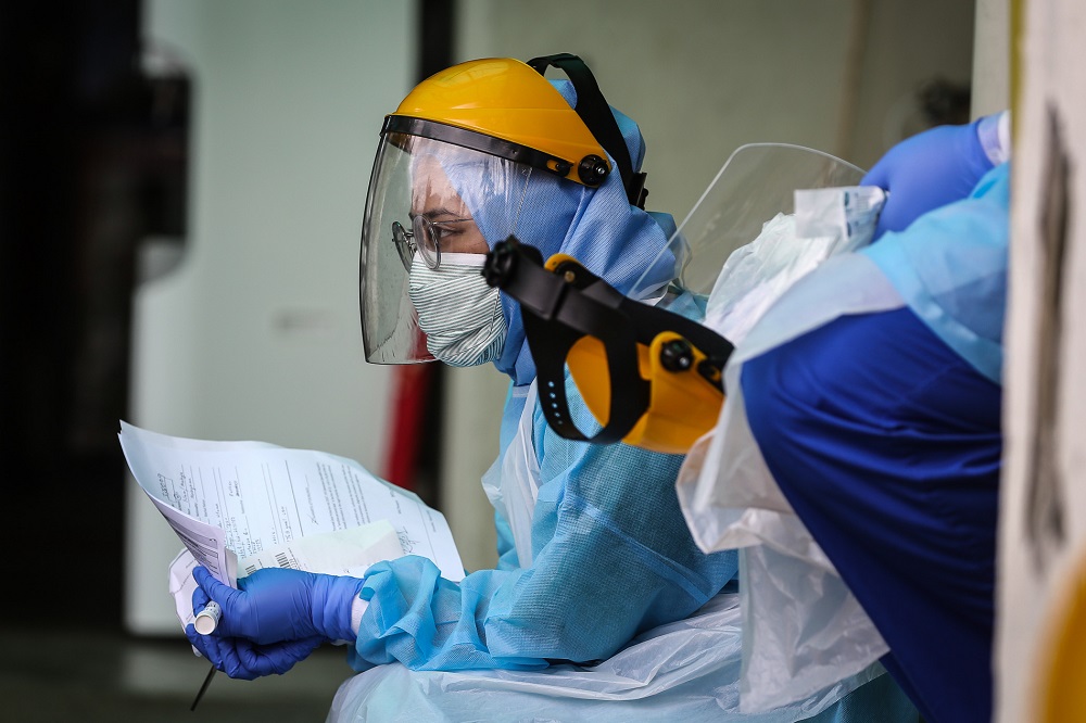 Health workers in protective suits are seen at a drive-through testing site for Covid-19 at KPJ Damansara Specialist Hospital in Petaling Jaya March 28, 2020. u00e2u20acu201d Picture by Yusof Mat Isa