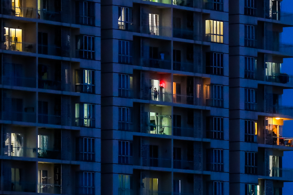 A man is seen at the window of his apartment, as most people stay at home amid the coronavirus disease (COVID-19) outbreak in Kuala Lumpur March 29, 2020. u00e2u20acu201d Picture by Firdaus Latifn