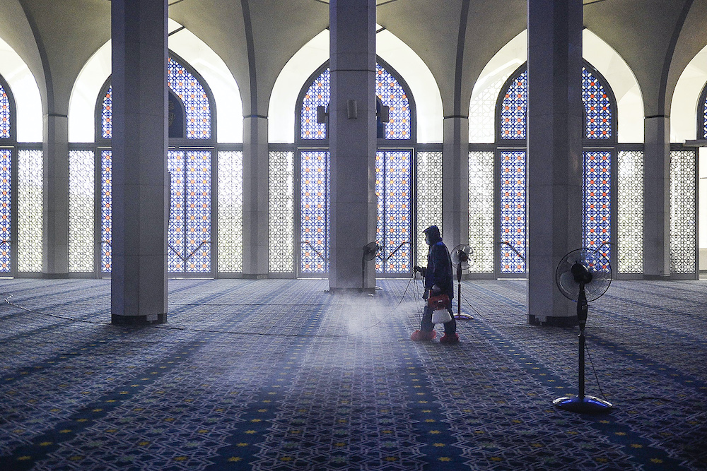 Seorang pekerja menyemprotkan disinfektan di masjid sebagai antisipasi penyebaran Covid-19, Shah Alam 29 Maret 2020. - Foto oleh Miera Zulyana