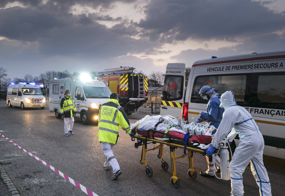 Emergency medical personnel carries a patient affected with Covid-19 from a military hospital to an ambulance before being transported aboard a medicalised TGV to be evacuated towards hospitals of other regions, Mulhouse March 29, 2020. u00e2u20acu201d AFP pic