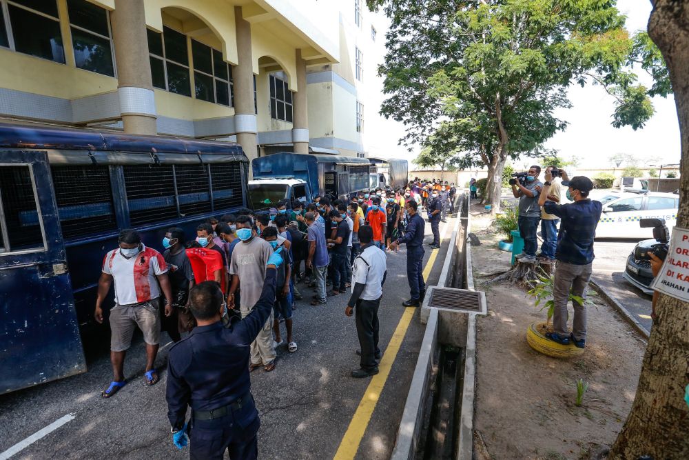 Police round up detainees who flouted the movement control order at the Butterworth Court Complex in Penang March 31, 2020. — Picture by Sayuti Zainudin
