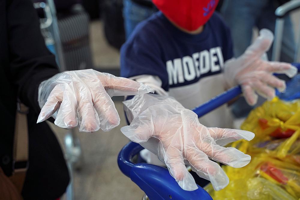 Travellers wear protective plastic gloves as a precaution after the Covid-19 outbreak, at Phnom Penh International Airport in Cambodia March 21, 2020. u00e2u20acu201d Reuters pic