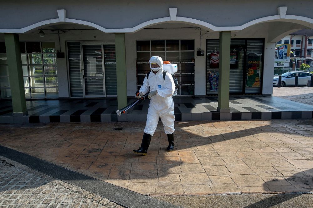 A city council worker sprays disinfectant at an eatery in Bazaar Medan Kidd to prevent the spread of Covid-19 in Ipoh March 25, 2020. u00e2u20acu201d Picture by Farhan Najib