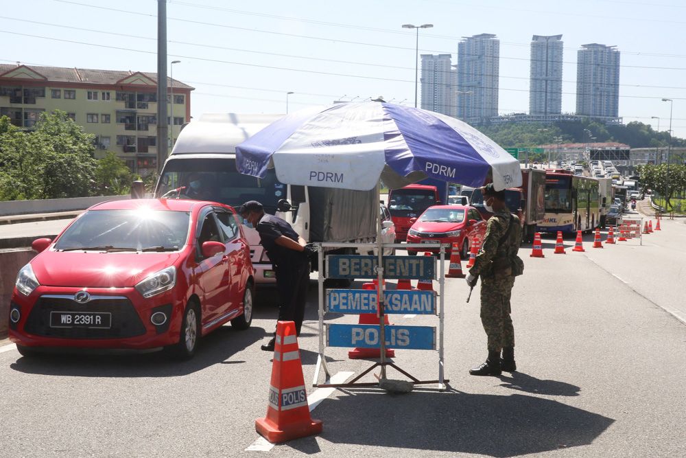 Malaysian Armed Forces and police personnel man a roadblock amid heavy traffic along the LDP in Petaling Jaya on March 25, 2020. u00e2u20acu201d Picture by Choo Choy May