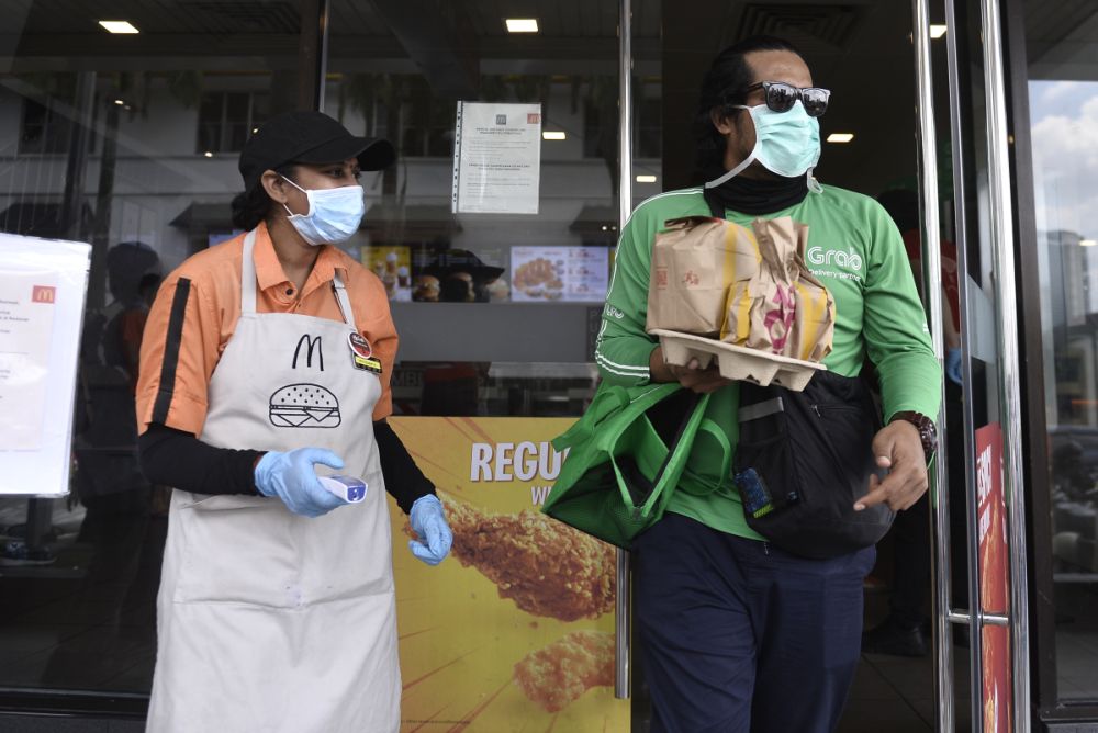 A GrabFood rider picks up his order at a McDonald’s outlet in Bangsar March 18, 2020. — Picture by Miera Zulyana