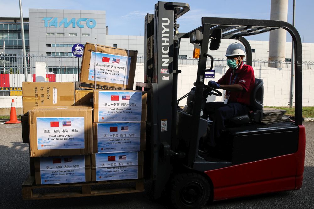 Pharmaniaga staff unload boxes of medical supplies donated by the Chinese Embassy in Shah Alam March 24, 2020. — Picture by Yusof Mat Isa