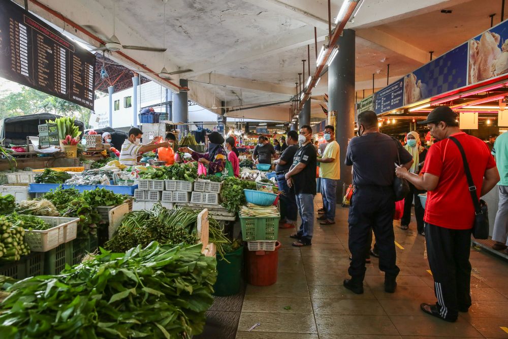 Customers observe social distancing guidelines as they do their shopping at the Shah Alam wet market March 26, 2020. u00e2u20acu201d Picture by Yusof Mat Isa