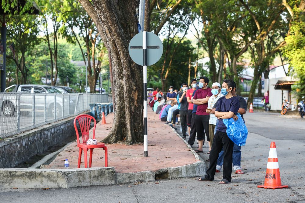 Customers observe social distancing guidelines as they queue outside the Shah Alam wet market March 26, 2020. u00e2u20acu201d Picture by Yusof Mat Isa