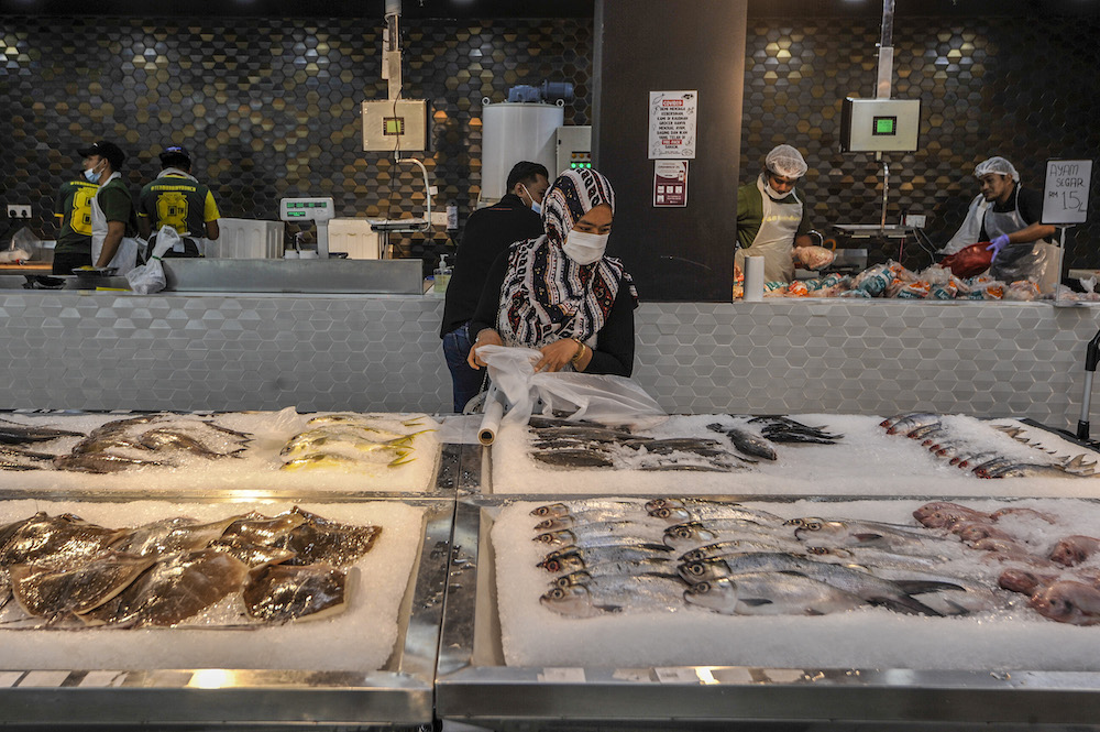 A customer selecting fish at a supermarket in Cyberjaya April 5, 2020. u00e2u20acu201d Picture by Shafwan Zaidon