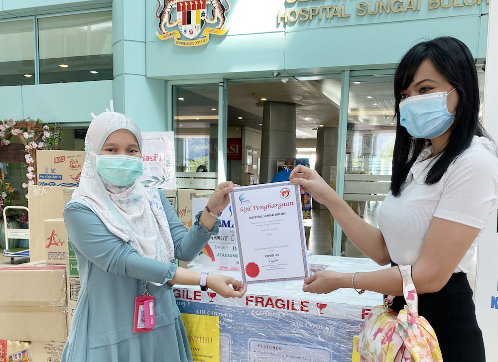 Malaysian sugar baby, Natalie, 28, handed over the items to Dr Ainul Husna at the Sungai Buloh Hospital including 10 portable air-conditioners which the hospital was in dire need of. — Picture courtesy of Sugarbook