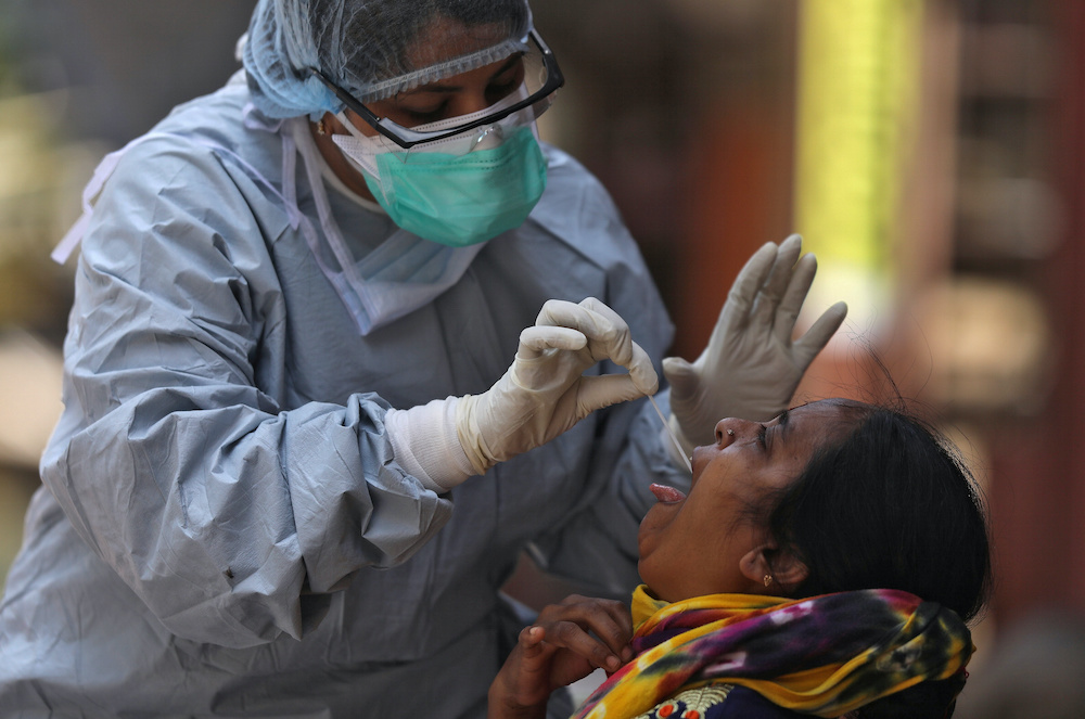 A doctor wearing a protective gear takes a swab from a woman to test for coronavirus disease (Covid-19), in Dharavi, one of Asia's largest slums, in Mumbai, India, April 9, 2020. u00e2u20acu201d Reuters pic