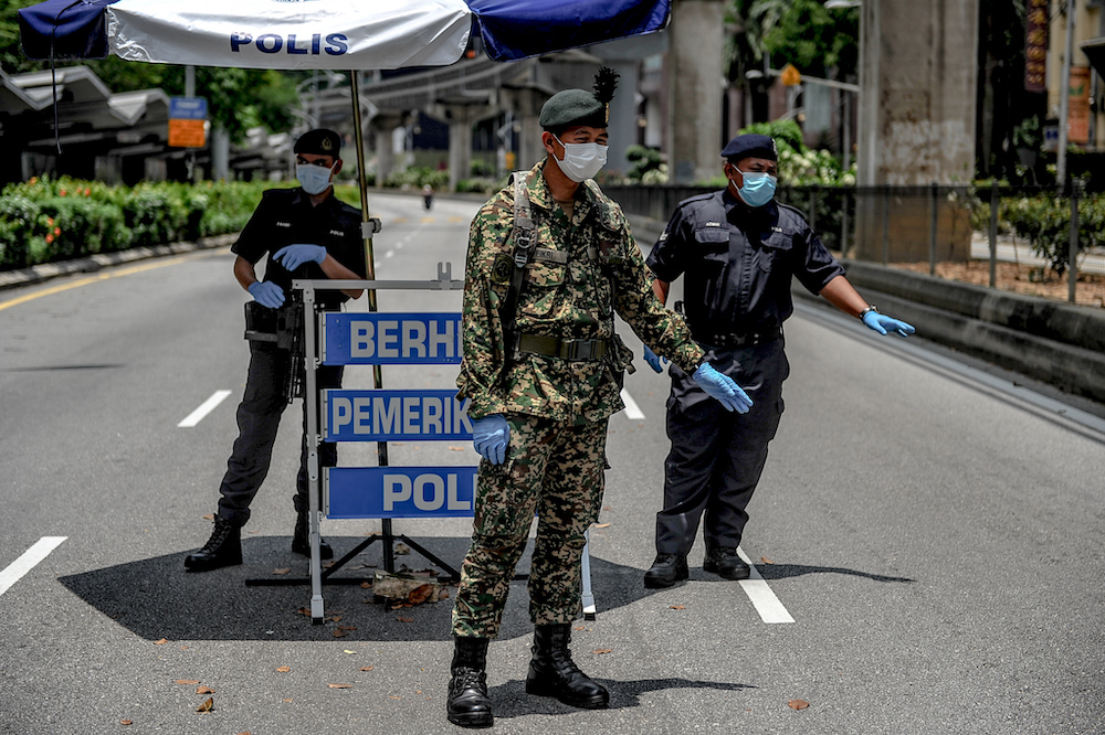 Soldiers and police officers conducting checks at a roadblock during the movement control order (MCO) in Kuala Lumpur. u00e2u20acu201d Picture by Firdaus Latifnnn