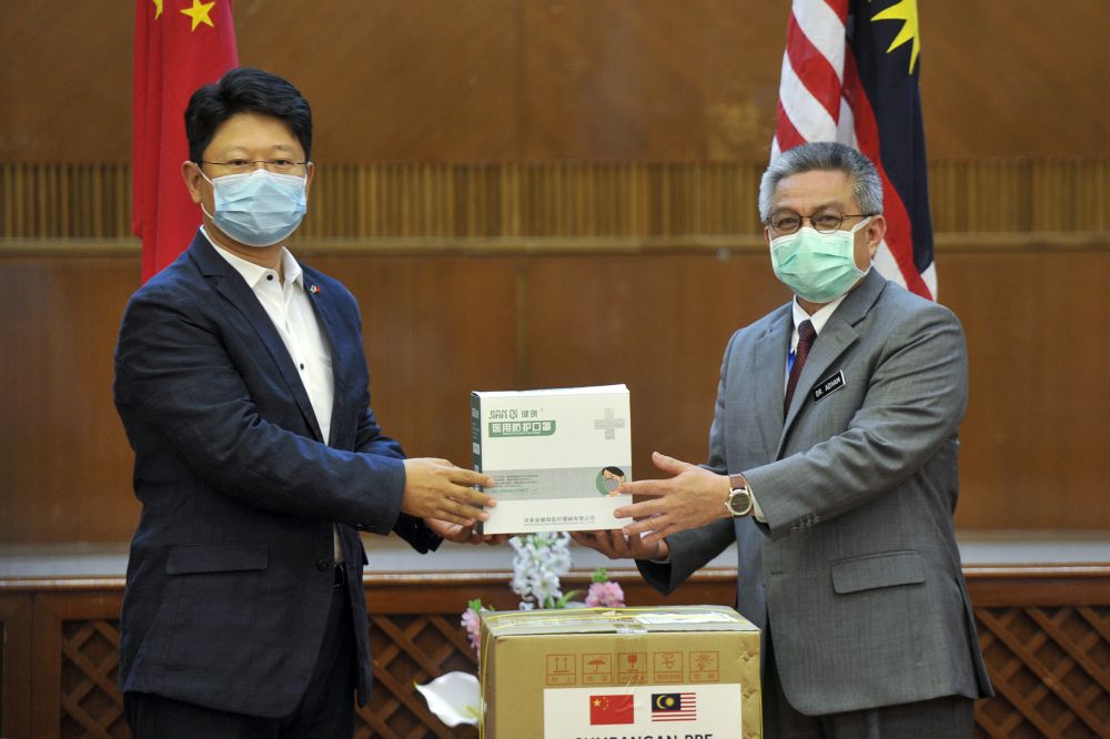 Datuk Seri Dr Adham Baba (right) receives a donation of face masks from Ambassador of China to Malaysia Bai Tian at the Health Ministry in Putrajaya April 2, 2020. u00e2u20acu201d Picture by Shafwan Zaidon