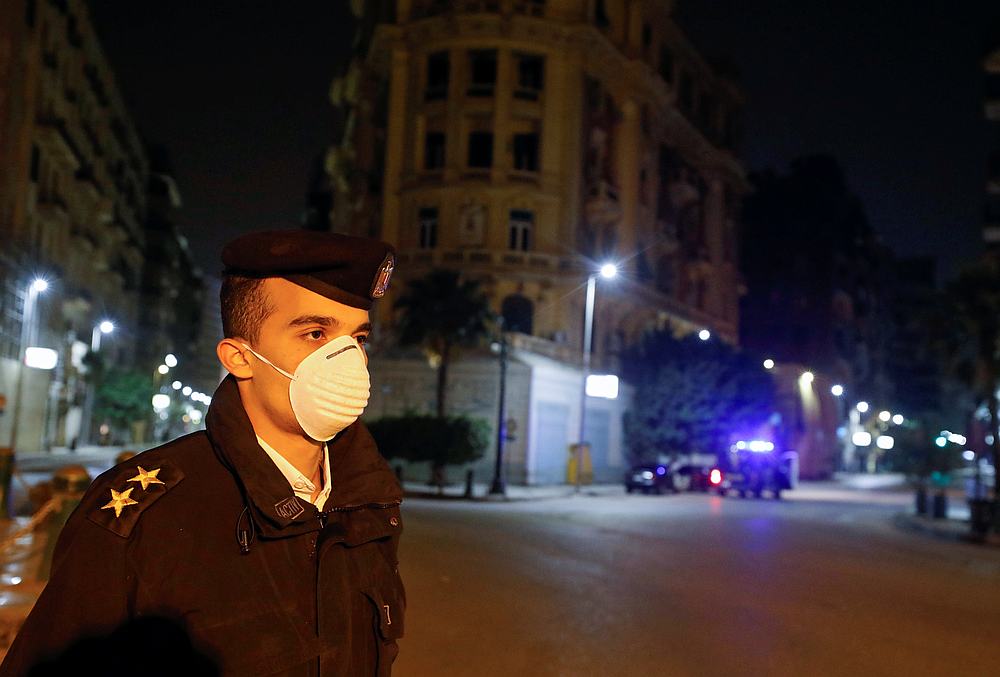 A police officer stands near Tahrir square during the first day of a two-weeks night-time curfew which was ordered by the Egyptian Prime Minister Mostafa Madbouly to contain the spread of the coronavirus disease (COVID-19), in Cairo, Egypt March 25, 2020.