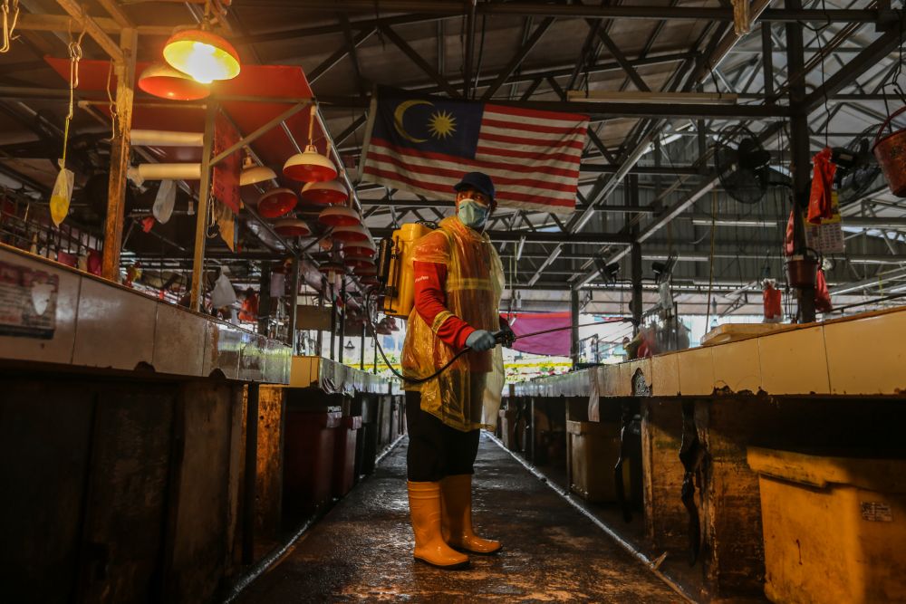 An Alam Flora personnel sprays disinfectant at the Chow Kit market in Kuala Lumpur April 29, 2020. u00e2u20acu201d Picture by Firdaus Latif