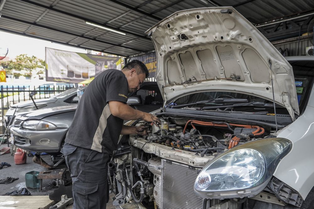 A mechanic repairs a car at his workshop in Kuala Lumpur April 14, 2020. u00e2u20acu201d Picture by Shafwan Zaidon