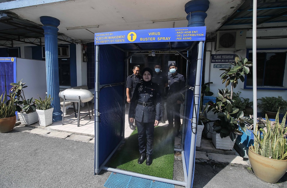 A police personnel tests a disinfection chamber at the entrance of the Kampung Tawas police station in Ipoh April 14, 2020. u00e2u20acu2022 Picture by Farhan Najib