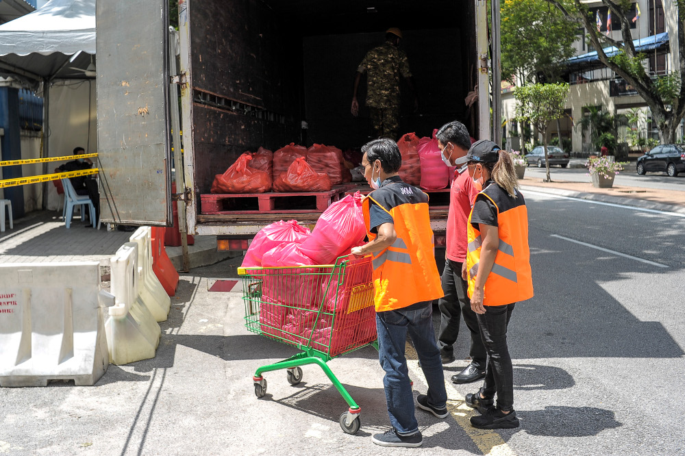 Social Welfare Department staff distribute meal packs for Plaza City One residents in Kuala Lumpur, April 15, 2020 u00e2u20acu201d Picture by Shafwan Zaidon