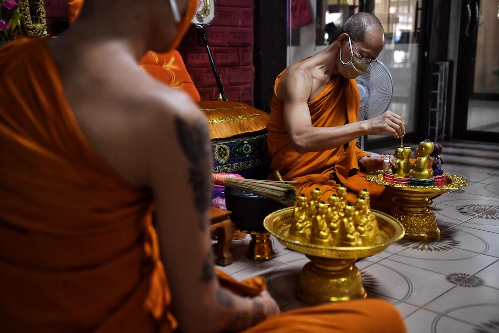 Monk Saneh Sumetho putting gold leaf and oil on Kuman Thong (Golden Son) dolls, believed to be infused with the spirit of a real child, at Wat Sam Ngam Buddhist temple in the central Thai province of Nakhon Pathom. u00e2u20acu201d AFP pic