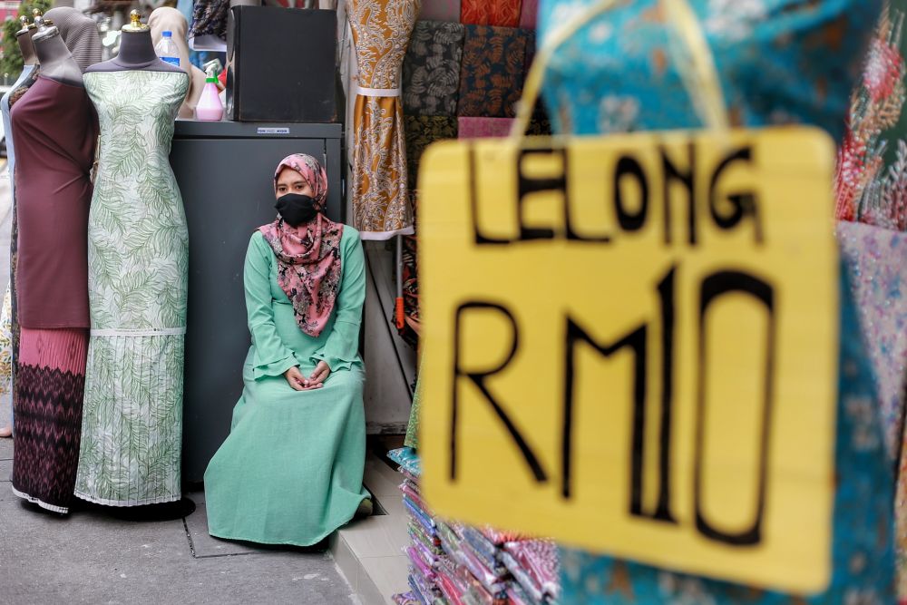 A worker waits for customers in front of a fabric store on Jalan Masjid India amid the conditional movement control order in Kuala Lumpur May 7, 2020. u00e2u20acu201d Picture by Ahmad Zamzahuri