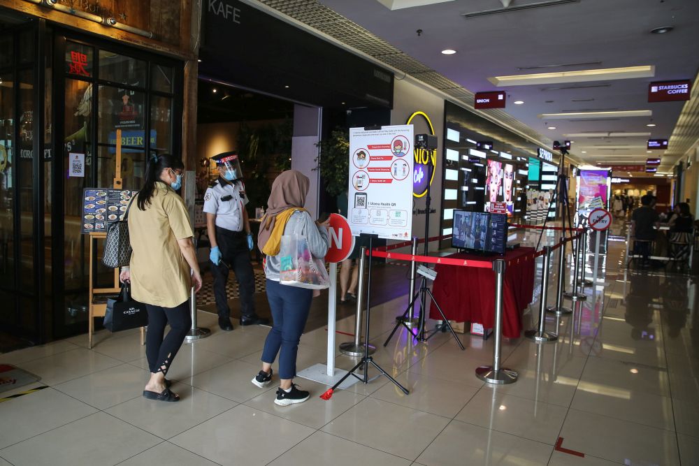 A security personnel monitors thermal scanners as patrons enter the 1Utama shopping mall in Petaling Jaya May 28, 2020. u00e2u20acu201d Picture by Yusof Mat Isa