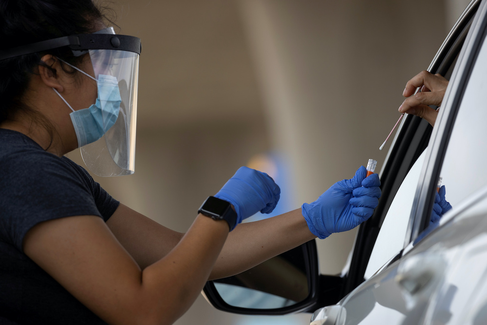 A San Diego County health nurse collects a sample from a patient at a drive-in Covid-19 testing site during the global outbreak of the coronavirus disease (Covid-19) in San Diego, California June 25, 2020. u00e2u20acu201d Reuters pic