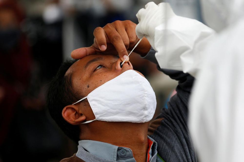 Healthcare workers take a swab sample from a passenger amid the coronavirus disease (Covid-19) outbreak, at a commuter train station in Bogor near Jakarta, Indonesia, May 11, 2020. u00e2u20acu201d Reuters pic