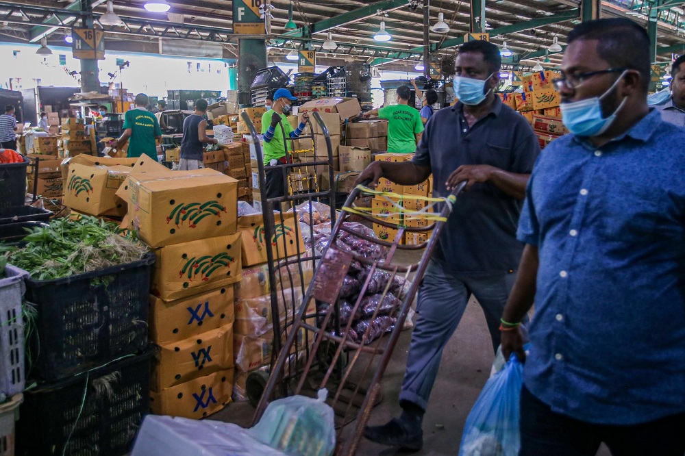 Workers are seen at the Kuala Lumpur Wholesale Market in Selayang June 24, 2020. ― Picture by Hari Anggara