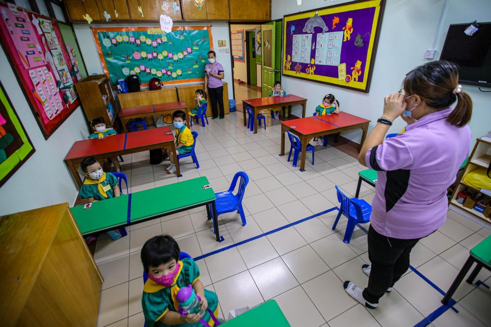 Preschoolers are seated accordingly to maintain social distancing while a teacher conducts a class at Mayter Kindergarten in Cheras July 1, 2020. u00e2u20acu201d Picture by Hari Anggara