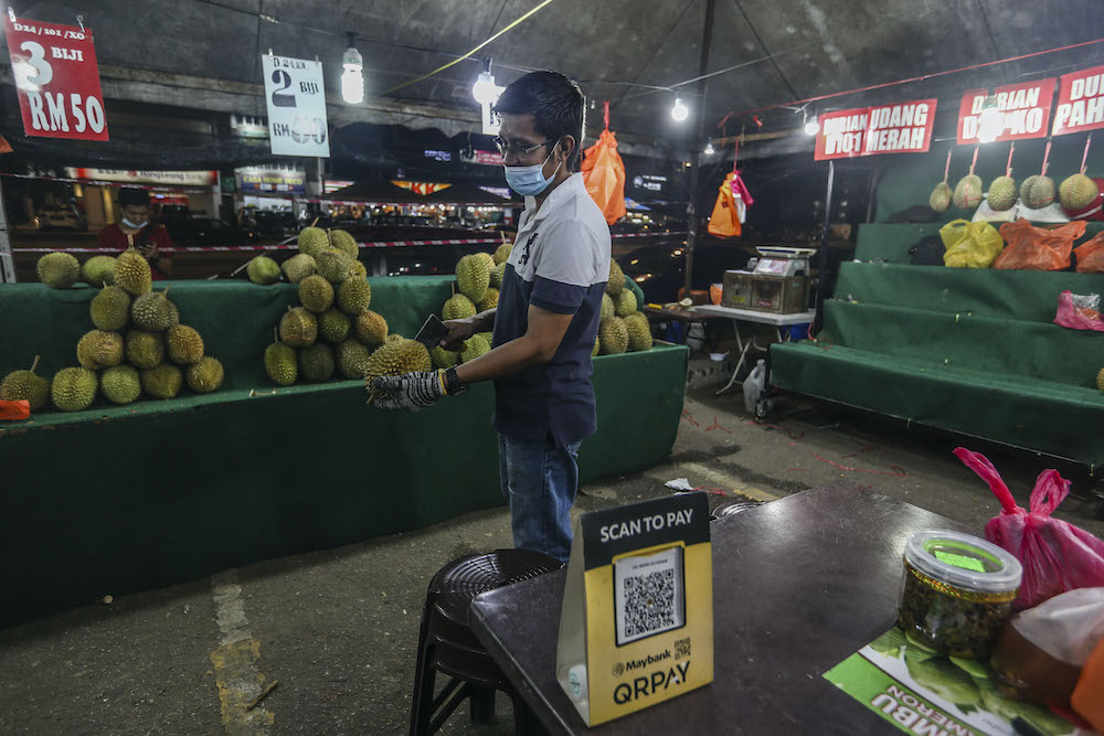 A vendor displays an e-wallet acceptance board at his durian stall in Setapak August 15, 2020. u00e2u20acu201d Picture by Firdaus Latif 