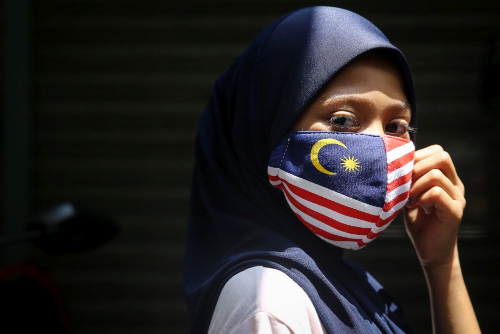 2020 年 8 月 16 日在吉隆坡拍摄的 Jalur Gemilang 设计中一名戴着面具的女士。 — 图片来自 Yusof Mat Isa