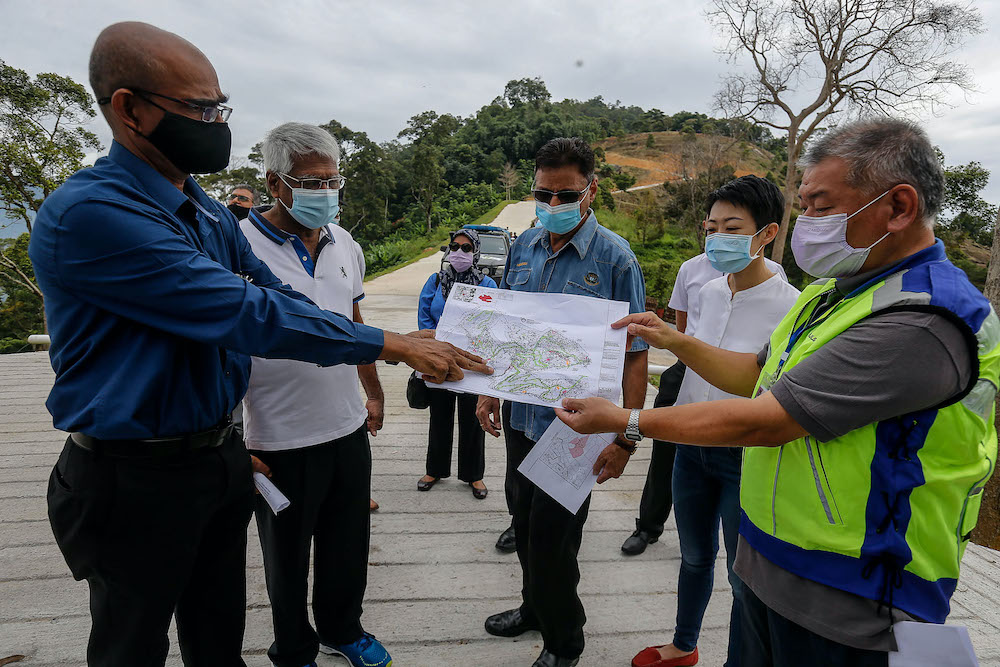 Penang Island Municipal Council Engineering Department Director PA Rajendran (centre) showing where the illegally conducted earthworks in Bukit Relau are being carried out on a map, September 14, 2020. — Picture by Sayuti Zainudin