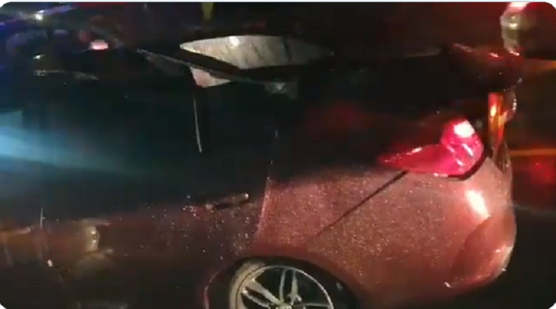 A screen capture of the video shows the car damaged on the roof and firemen engaged in a rescue operation.