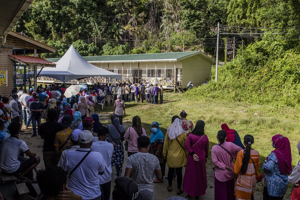 Voters wearing protective masks queue up to cast their votes during the Sabah state election in SK Pulau Gaya September 26, 2020. u00e2u20acu201d Picture by Firdaus Latif
