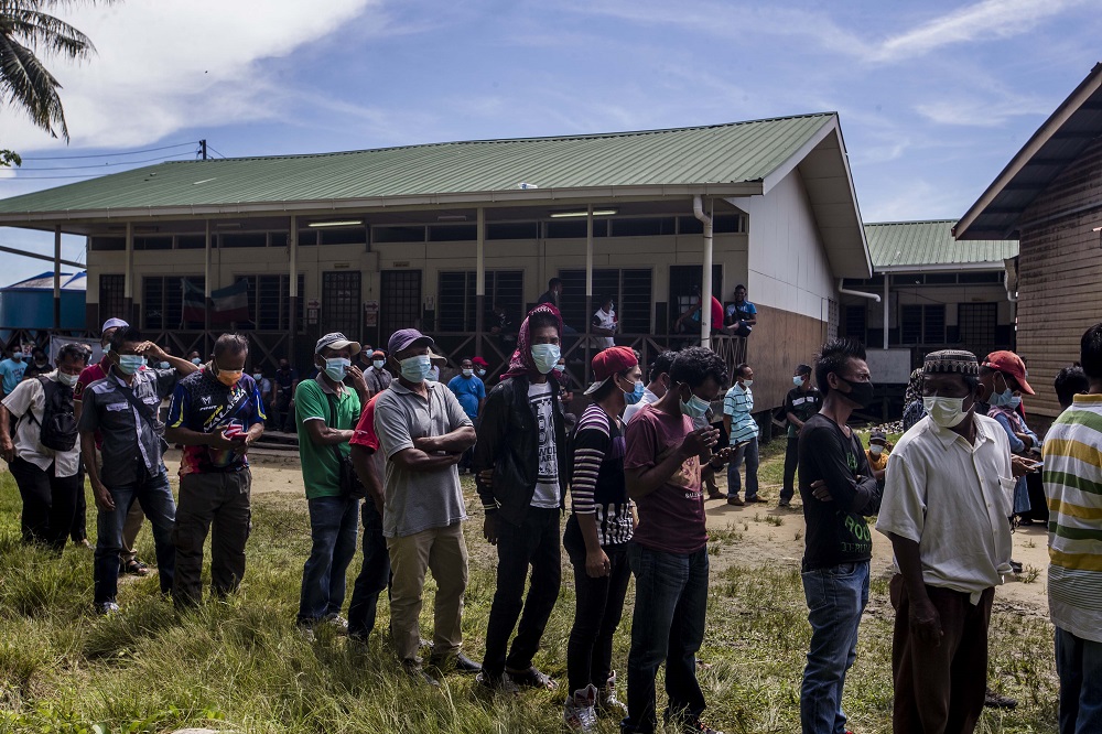 Voters wearing protective masks queue up to cast their votes during the Sabah state election in SK Pulau Gaya September 26, 2020. — Picture by Firdaus Latif