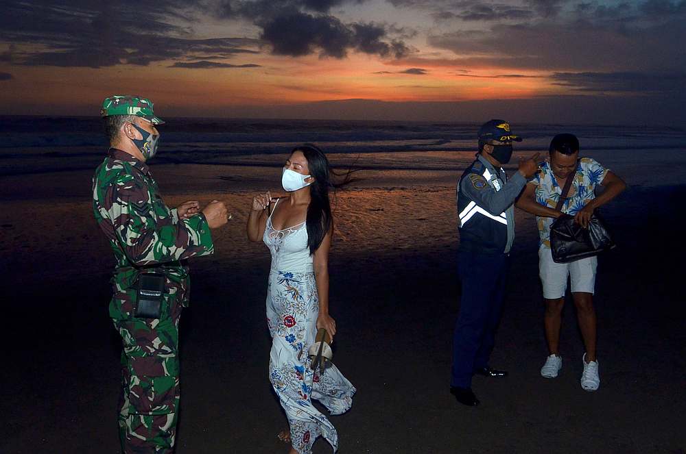 Officers wearing protective face masks warn visitors on wearing protective masks, amid the Covid-19 outbreak in Badung, Bali Province, Indonesia September 3, 2020. u00e2u20acu201d Antara Foto via Reuters