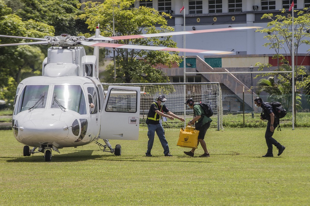 Election Commission personnel carry a ballot box to a helicopter ahead of the Sabah state election in Moyog September 25, 2020. u00e2u20acu2022 Picture by Firdaus Latif