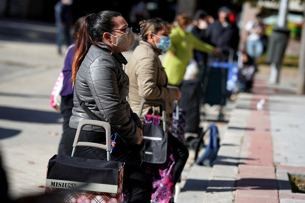 People queue to receive food from NGO Madrina Foundation's members, amid the coronavirus disease outbreak, in Madrid October 30, 2020. — Reuters pic