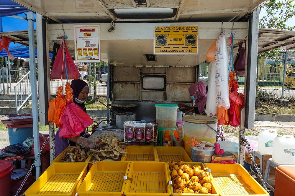 一位小商人在2020年10月27日在八打灵再也的摊位卖炸的小吃—照片作者Miera Zulyana